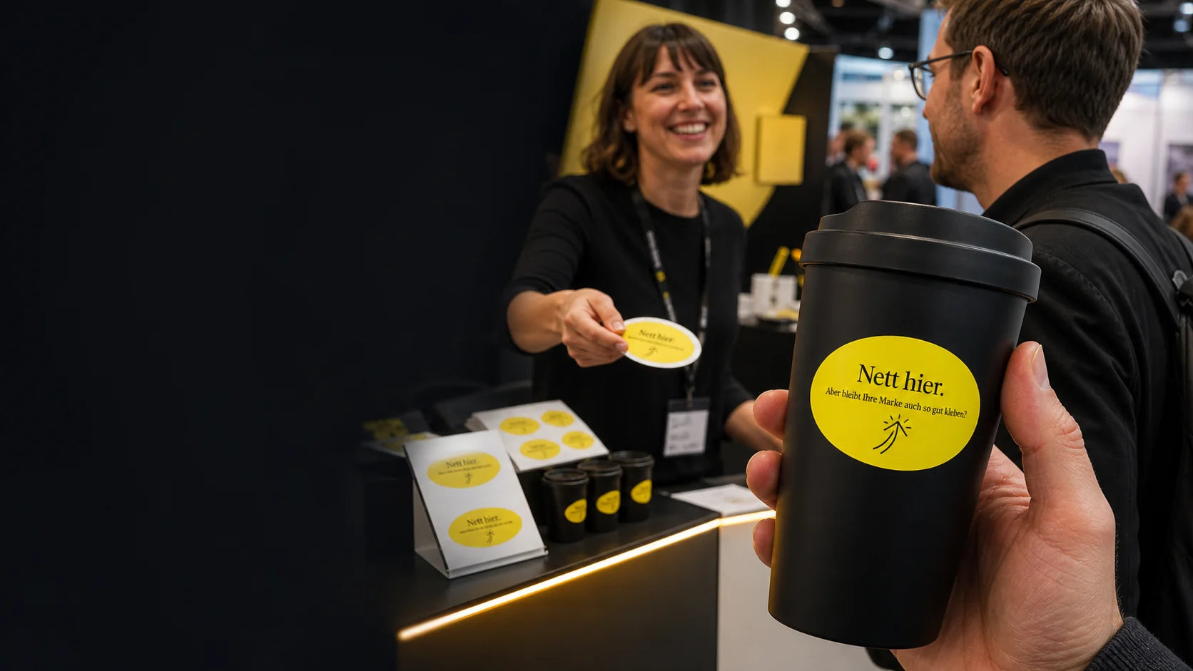 Unternehmen nutzt personalisierte Nett hier Aufkleber als Werbemittel auf einer Messe